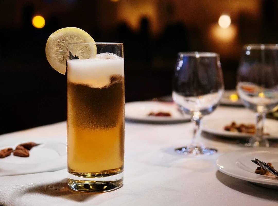 Eplemost med is og sitronskive i høyt glass på hvit duk